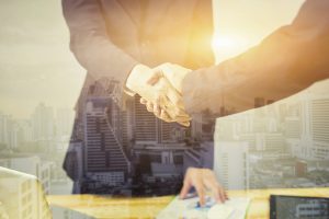 two people shaking hands standing at the working place in cityscape