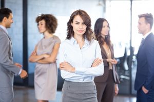 confident-woman-smiling-while-people-interacting-with-each-other