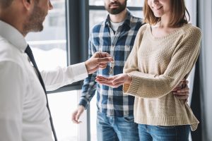 couple taking keys from real estate agent