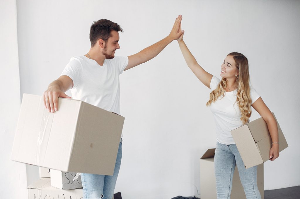 Couple moving. People use a boxes. Girl in a white t-shirt.