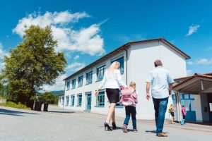 Parents walking their child to school.